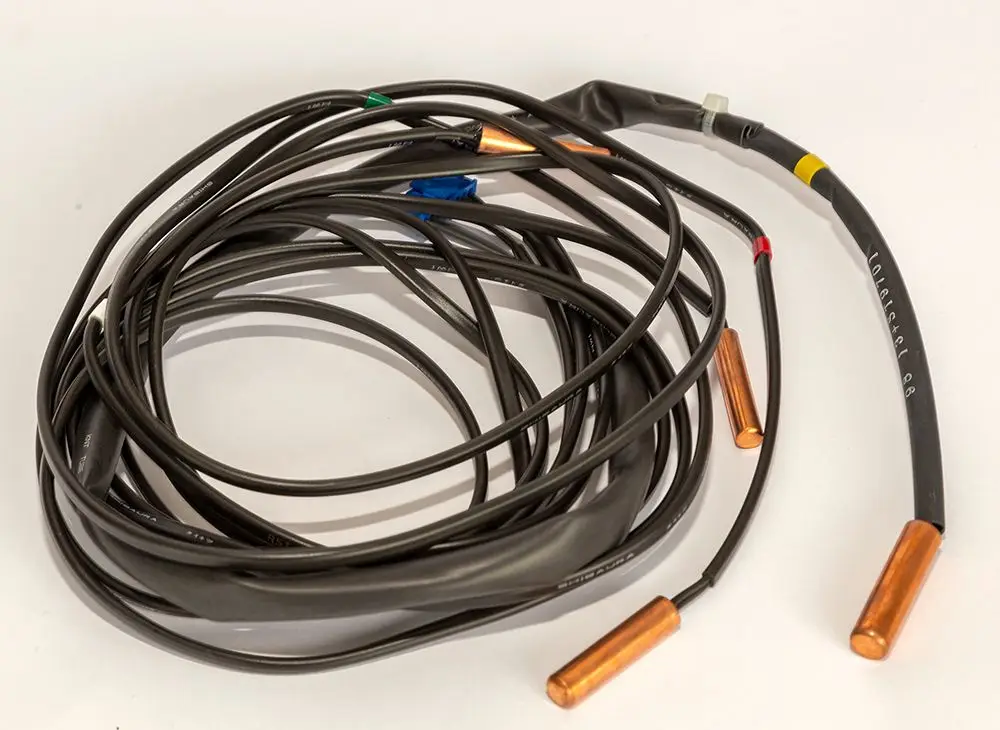 Schwarzes Kabel mit mehreren abgehenden Leitungen und Kupferenden, vermutlich für einen Temperaturfühler von Daikin, sichtbar gewickelt auf einem hellen Hintergrund.